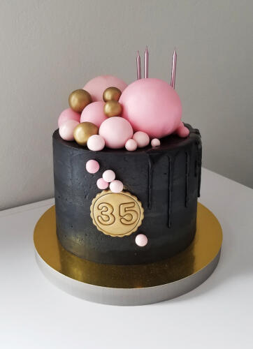 czarny tort z różowymi kulkami